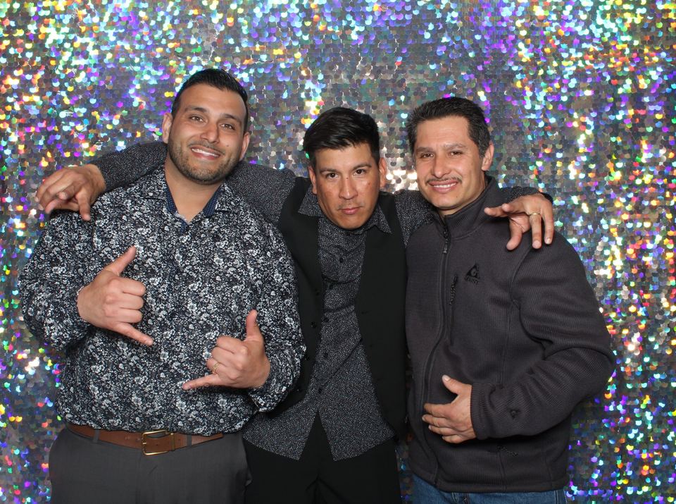Three friends posing in front of a sequin backdrop